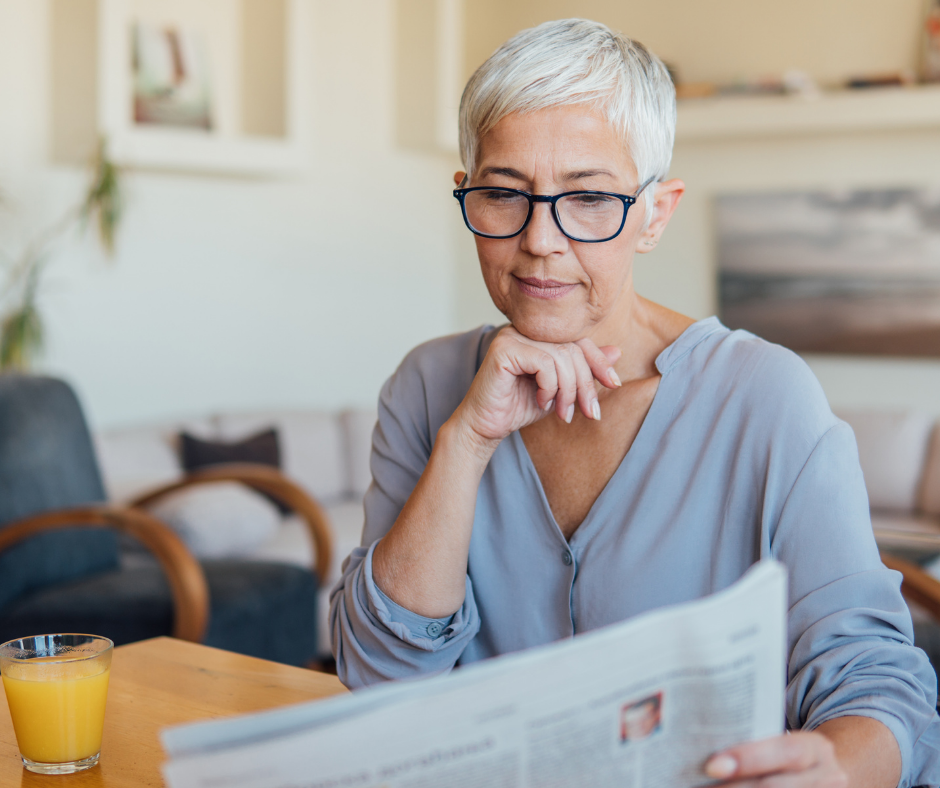 Mature woman in menopause reading newspaper