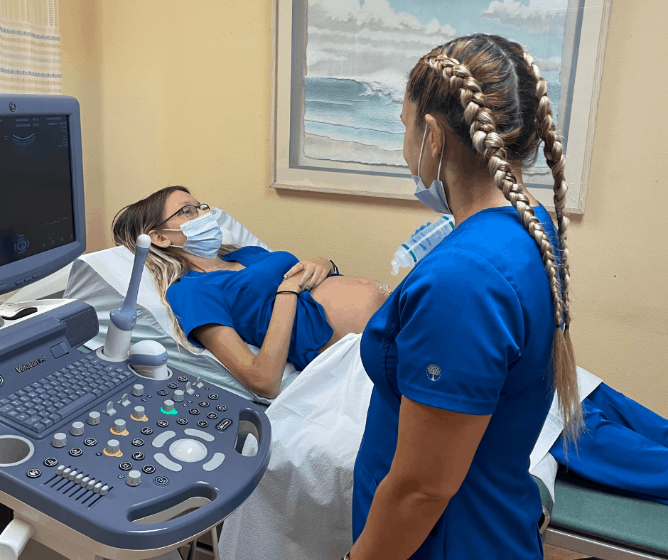 pregnant woman being prepped by nurse at prenatal care visit
